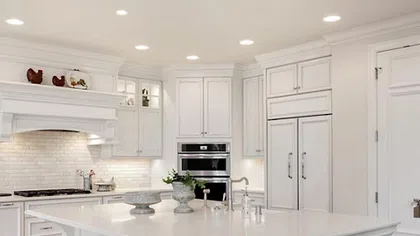Modern white kitchen with an island, sleek appliances, and elegant lighting for a stylish ambiance.