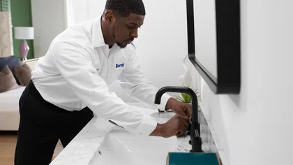 A professional plumber installs a modern faucet in a stylish bathroom setting.