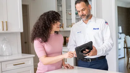 Bardi technician showing quotes to a customer in their home.