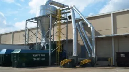 Industrial dust collection system with large metal pipes and cyclone separator outside a commercial building