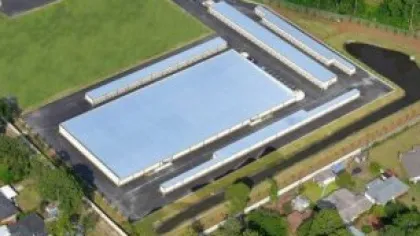 Aerial view of large rectangular warehouse with surrounding storage units and paved access roads