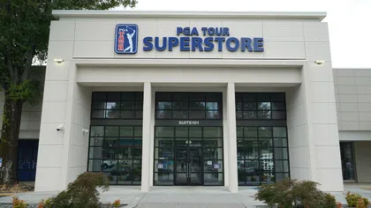 Front entrance of PGA Tour Superstore with glass doors and signage on a cloudy day