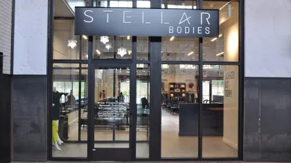 Front view of Stellar Bodies fitness studio with glass doors and modern interior design.