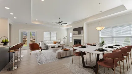 a large living room with a dining table and chairs