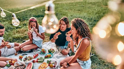 a group of people sitting around a table with food on it