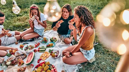 a group of people sitting around a table with food on it