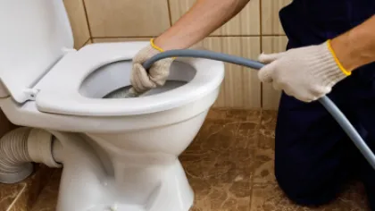 a person repairing a toilet