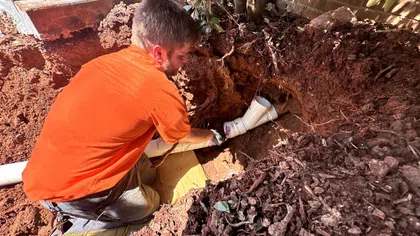 Estes Services technician repairing an underground sewer line outside a residential home.