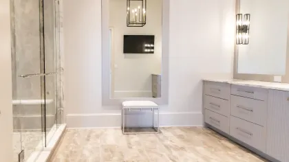 Spacious modern bathroom with stylish fixtures, large mirror, and elegant lighting.