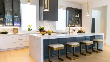 Modern kitchen design featuring a marble countertop and gold-accented seating.