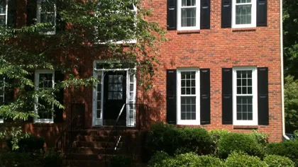 a brick house with a lawn in front of it