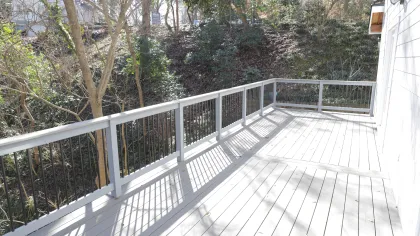 a wooden deck with trees on the side