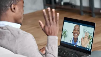 a man holding his hand up in front of a laptop