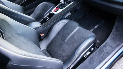 Modern car interior with black leather seats, manual gear shift, and center console cup holders