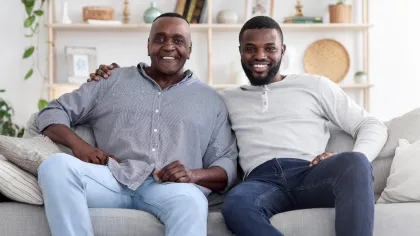 two men sitting on a couch