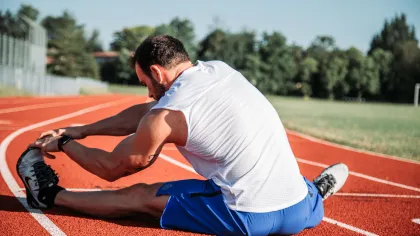 a man stretching on a track
