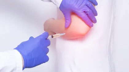 a person in a blue glove holding a syringe
