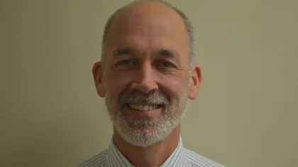 a man with a beard smiling