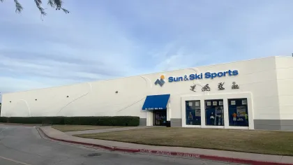Sun & Ski Sports store exterior with blue signage and sports icons under a clear sky