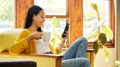 a woman sitting at a table and looking at her phone