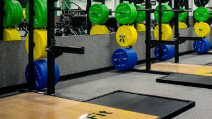Weightlifting area with colorful bumper plates and squat racks at YouFit Gyms.