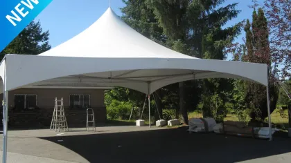 Large white outdoor event tent with peak roof set up on pavement near trees and ladders under clear sky.