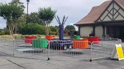 Colorful outdoor children's trampoline ride with multiple circular trampolines surrounded by a safety fence