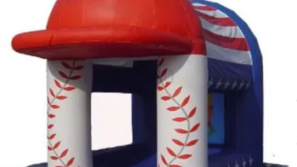 Inflatable bounce house shaped like a red baseball cap with white pillars decorated with red leaf patterns.