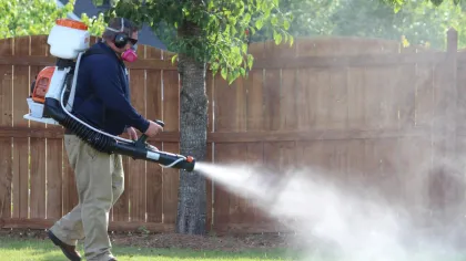 man spraying yard for mosquitoes