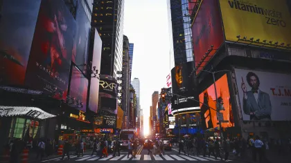 a busy city street with Times Square in the background
