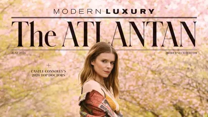 Woman in a colorful jacket stands in front of blooming pink trees on June 2026 The Atlantan magazine cover.