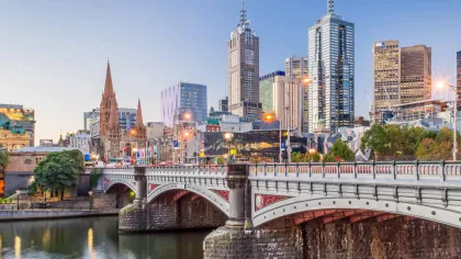 a bridge over a river with a city in the background