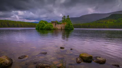 a body of water with rocks and trees around it