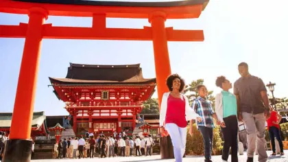a group of people standing in front of a red structure