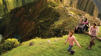 a group of people running on a grassy hill
