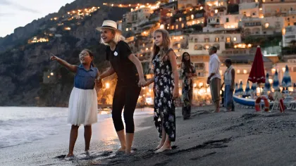 a group of women posing on a beach