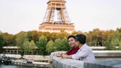 a man and woman hugging in front of a large tower