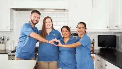 a group of people posing for a photo in a kitchen