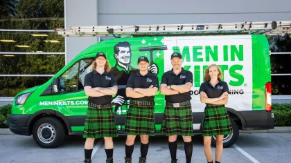 a group of people in kilts standing in front of a van