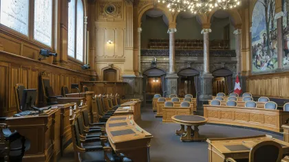 Elegant wood-paneled parliamentary chamber with curved desks, leather chairs, chandeliers, and decorative murals.