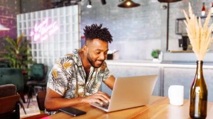 a man sitting at a table using a laptop