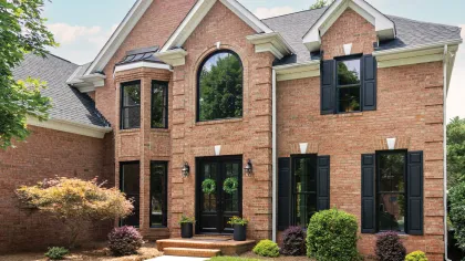 Brick home with black windows and shutters - Windows impact on home design