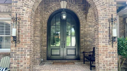 Arched double entry doors with glass and black paint to accent the brick home - from North Georgia Replacement Windows