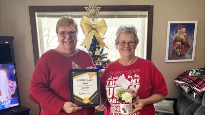 a couple of women holding a plaque