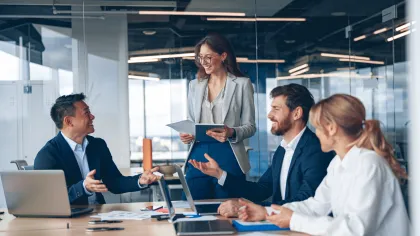 Professionals collaborating in a modern office setting during a business meeting.