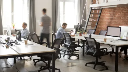Modern office space with engaged employees working and collaborating in a bright setting.
