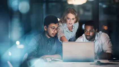 a group of people looking at a laptop