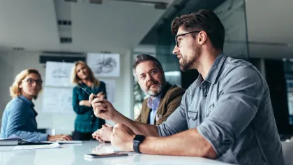 Business team discussing ideas in a modern office setting during a meeting.