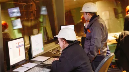 a group of people in hardhats working at computers