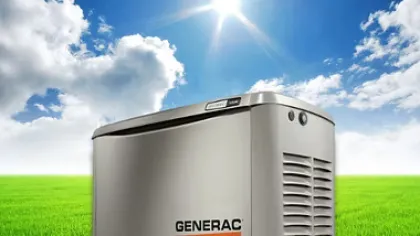 Generac home standby generator on green grass under bright blue sky with sun and clouds